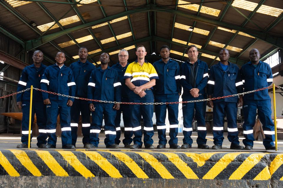 The fabrication team in navy overalls